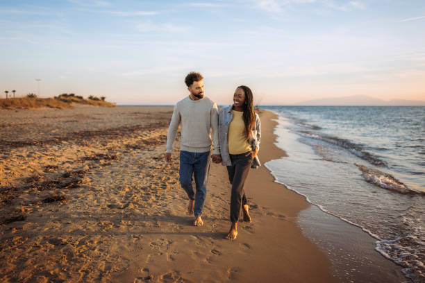 istock Young happy couple enjoys walk by the beach 1444134306