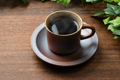 Café negro caliente aislado en mesa de madera photo