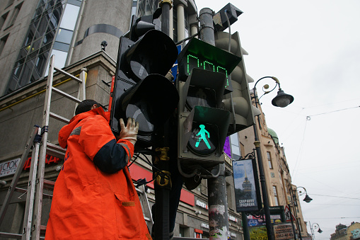 Push Button and Crossing sign for pedestrian crosswalk on a yellow post along the city street