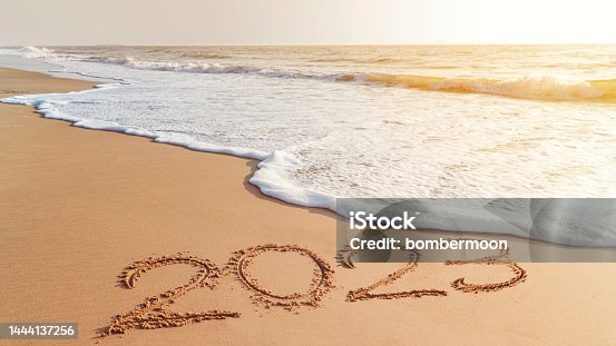 istock The year 2023- handwriting on sand beach, Happy New Year coming concept. White waves are lapping toward the shore. 1444137256