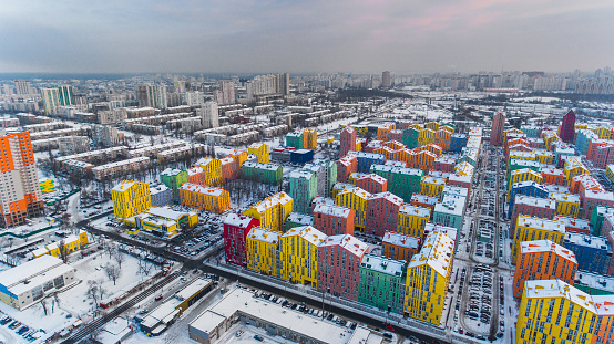 Snow-covered colored Kyiv residential buildings from the air. View from the left bank to the right