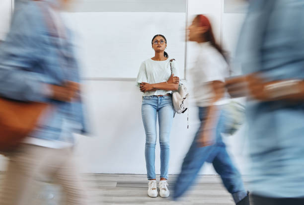 student, anxiety and woman in busy college campus with depression, sad and mental health problems. burnout, stress and tired girl thinking about exam, assignment or project deadline at university - pijn fotos stockfoto's en -beelden
