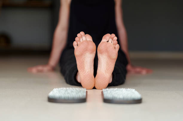 istock Selective focus. Mans legs after standing on sadhu board with sharp nails. Male relaxe after yoga practice sitting on the floor in studio indoors 1444139462