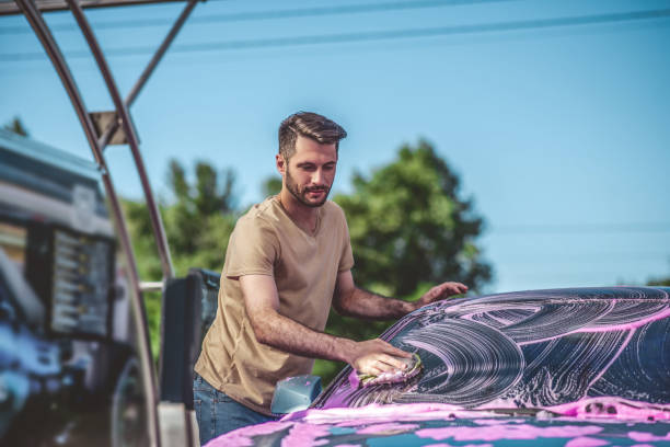 istock Service station worker cleaning an automobile windshield outdoors 1444141068