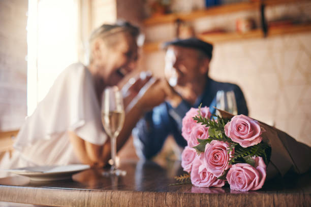 愛、お祝い、そしてトーストのためのシャンパンとカップルの結婚記念日のためのバラの。関係のコミットメントでロマンチックで幸せで思いやりのある高齢者は、親密なデートを楽しんで� - champagne toast wine restaurant ストックフォトと画像