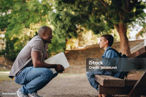 Mentor Talking To A Young School Kid Outside Class Stock Photo - Download Image Now - Child, Teacher, Student