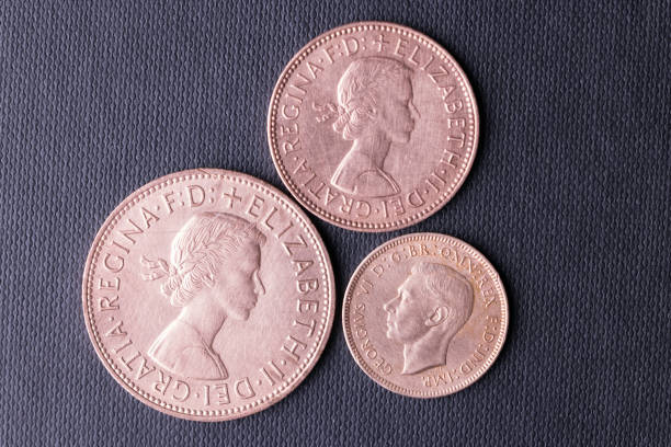 Obsolete British coins Haverfordwest, Wales - November 23, 2022: Studio shot of obsolete British one penny, half penny and farthing coins. The latter two were originally cut from a one penny coin, either into halves or quarters (fourthings). The farthing was phased out in 1960 and the larger penny and the mid-sized half penny went after UK decimalisation in 1971. george vi stock pictures, royalty-free photos & images