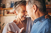 Dancing, happy senior couple smile together and dance with love in retirement. Anniversary celebration at home, mature married healthy man and active woman support each other in retired old age