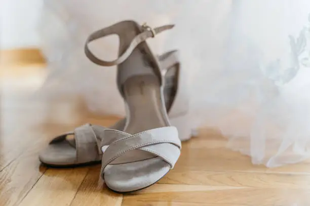 Light grey hight heels in front of a wedding dress
