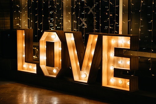 Big wooden letter of the word LOVE with light bulbs