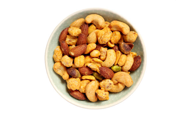 Roasted nuts in a small bowl isolated on white background stock photo