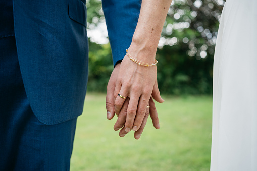 Close-up of the entwined hands of bride and groom