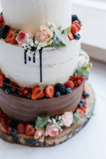 Semi-naked cake in brown and white decorated with flowers and berries Semi-naked cake in brown and white decorated with flowers and berries amerikanische heidelbeere stock pictures, royalty-free photos & images