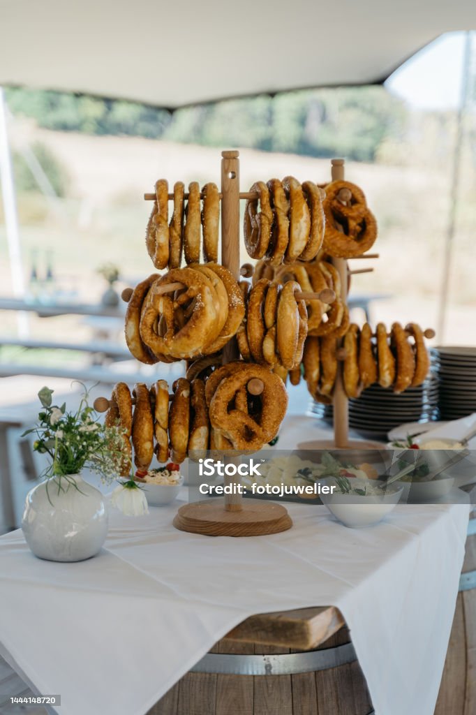 Wooden stand with pretzels and butter variations on a wine barrel Holzständer mit Brezeln und Buttervariationen auf einem Weinfass Bakery Stock Photo