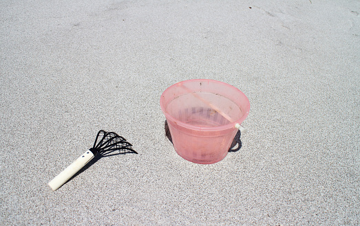 Sandy beach with bucket and bear hand