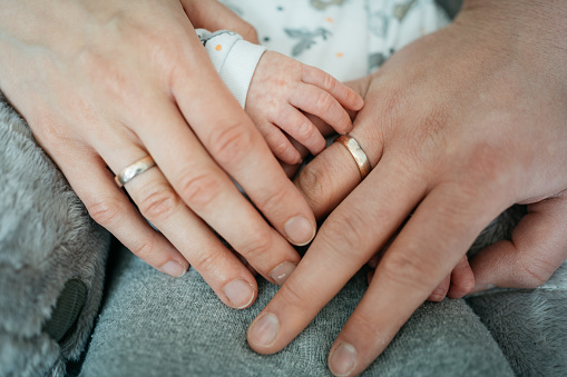 Close-up of hands of a couple and their baby