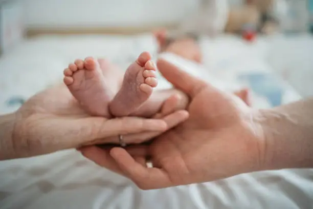 Close-up of babyfeet being helt by the hands of its parents