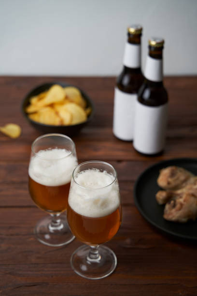 istock Two glasses with beer, snacks and bottles 1444156420