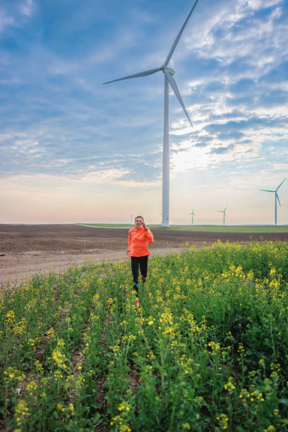 istock Running through crop plants in rural area with wind turbines 1444157011