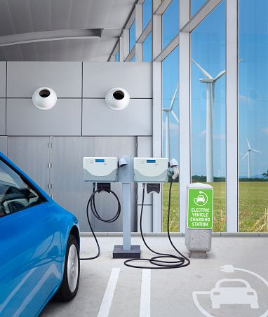 Electric car charging renewable energy at electric vehicle charging station at wind farm