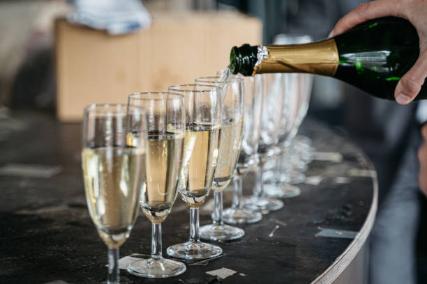 le vin mousseux est versé dans des verres - champagne pouring champagne flute glass photos et images de collection