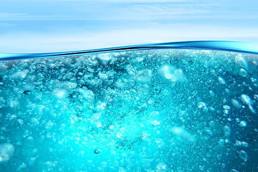 Water wave, transparent surface with bubbles. Undersea View