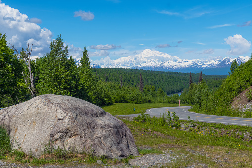A big boulder and Denali on the road to Denali National Park in Alaska.