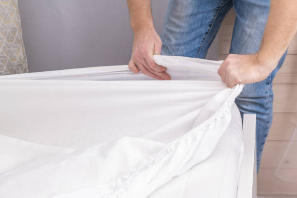 istock A man makes his cozy bed with fresh bright white bed linen. Making the bed with fresh bed linen by white man. The day of the change of bedclothes. The day of washing bedclothes in the laundry room. 1444173017