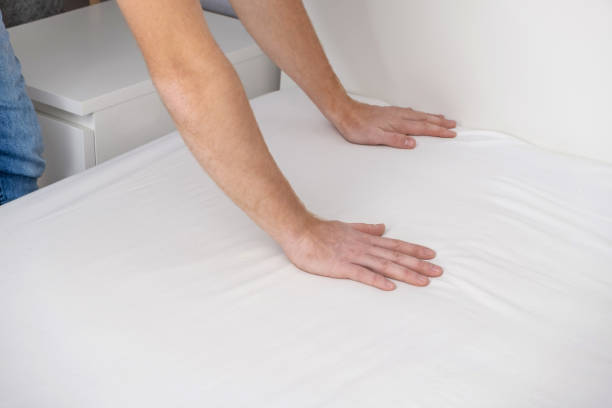 istock A man makes his cozy bed with fresh bright white bed linen. Making the bed with fresh bed linen by white man. The day of the change of bedclothes. The day of washing bedclothes in the laundry room. 1444173024