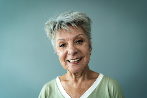 Portrait of a senior woman on a gray background