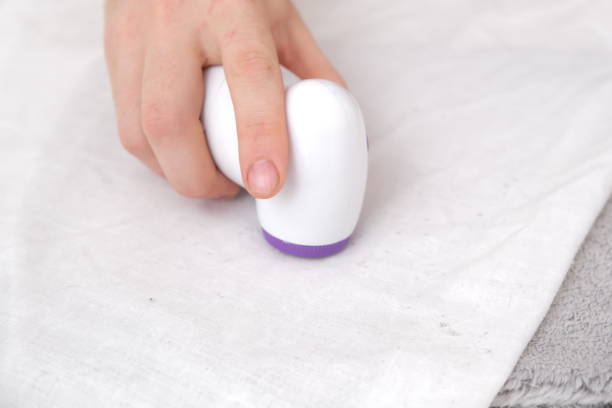 istock man removes fabric pills using lint shaver. 1444176037