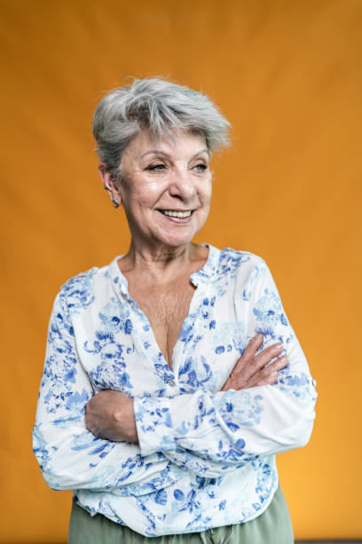 Senior woman looking away on an orange background