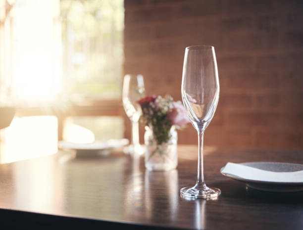istock Empty glass on table for wine, champagne or alcohol at dinner in romantic restaurant, home or diner. Luxury, lunch or supper with crystal wine glass, plate and flower for reception, banquet or meal 1444178050