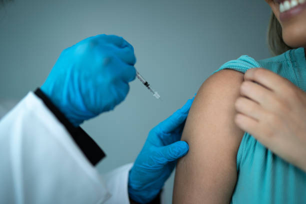 istock Doctor's hand vaccinating a woman on a studio shot 1444178909