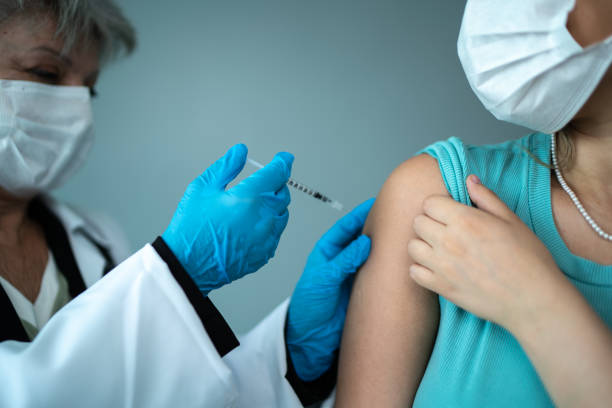 istock Doctor's hand vaccinating a woman on a studio shot 1444178922