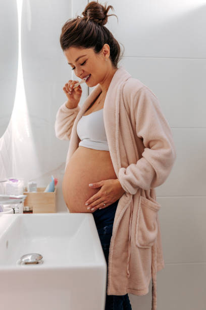 istock Happy pregnant woman brushing teeth. 1444180000