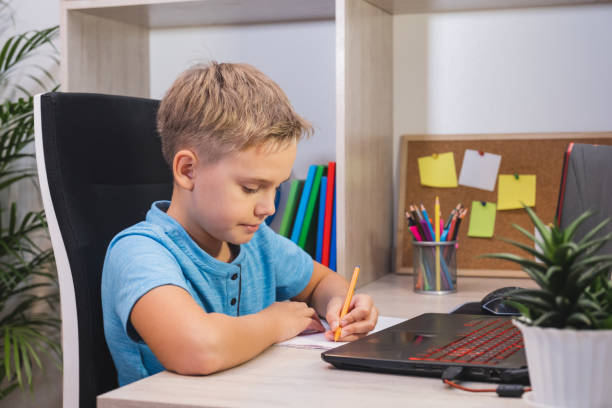 istock Distance learning online education. Schoolboy learning online at home at table using laptop 1444182117