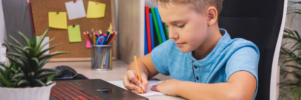istock Distance learning, online education. A schoolboy studies at home with laptop and does school homework. 1444182167