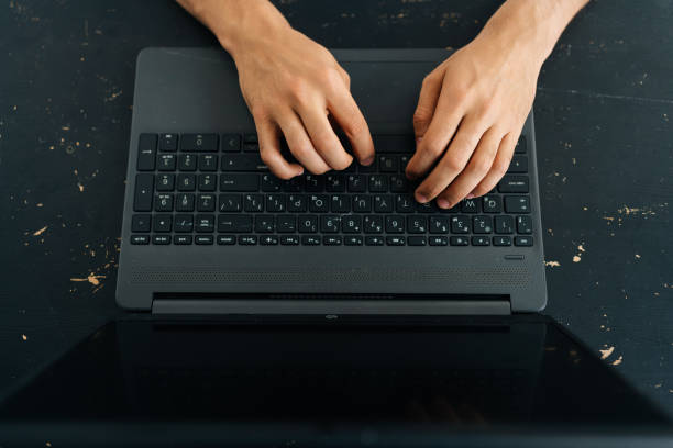 istock Close-up high angle view of unrecognizable business man typing texting on modern laptop keyboard, male employee sitting at black desk working on computer 1444183570