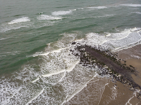 aerial shot of waves coming ashore along the coast