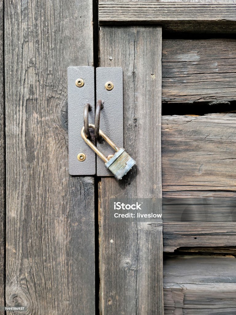 Old Padlock On Wood Door Closeup of a weathered padlock on an old wooden door Building Entrance Stock Photo