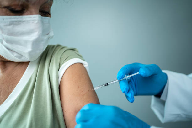istock Doctor's hands vaccinating a senior woman 1444187306