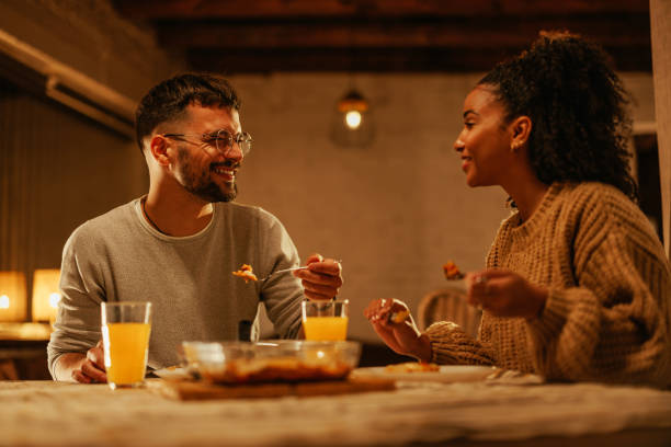 istock Cheerful couple eating dinner in apartment. 1444187383