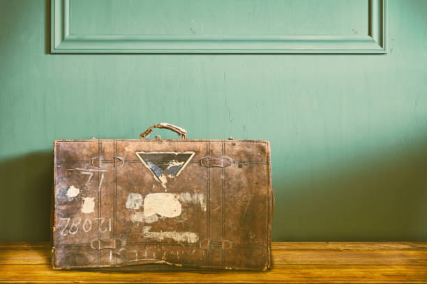 выветрившийся винтажный дорожный чемодан в старой комнате - suitcase label old old fashioned стоковые фото и изображения