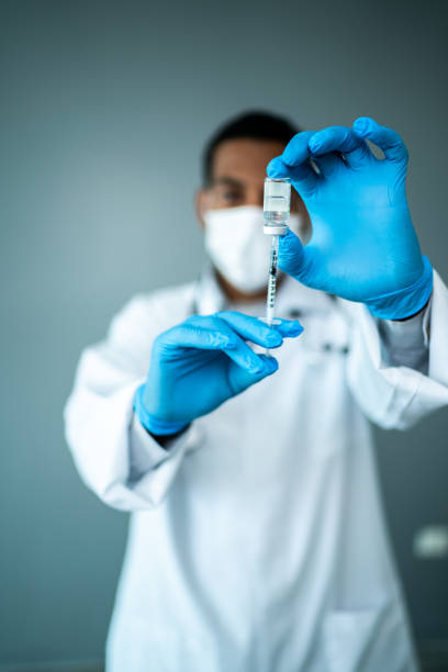 istock Doctor wearing a protective face mask and preparing injection on a studio shot 1444188593