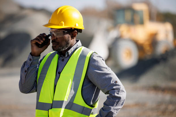 ritratto di operaio o ingegnere industriale con elmetto e occhiali protettivi con walkie-talkie in cantiere - stockyards industrial park foto e immagini stock