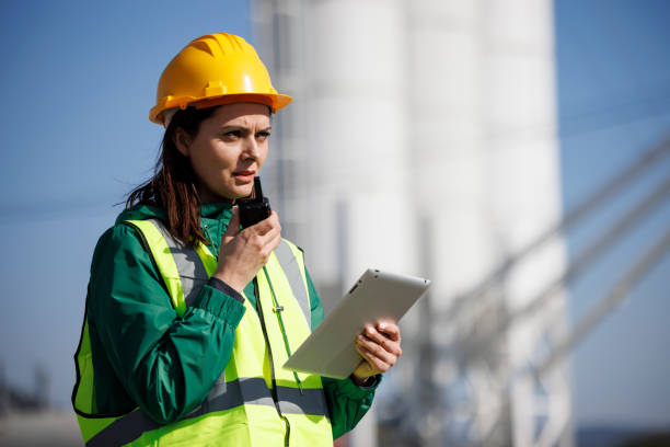 portret inżynierki używającej krótkofalówki i tabletu cyfrowego w zakładzie przemysłowym - oil industry digital tablet manual worker mining zdjęcia i obrazy z banku zdjęć