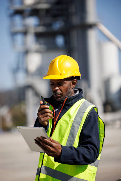 portrait of industry worker or engineer using walkie-talkie and digital tablet at industrial facility - mining engineer oil industry construction site imagens e fotografias de stock