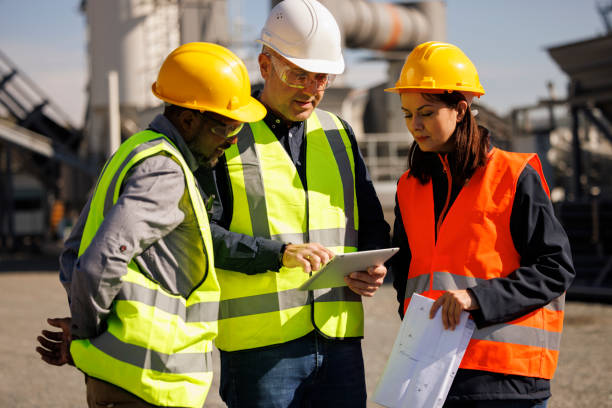 Engineers discussing at industrial facility stock photo