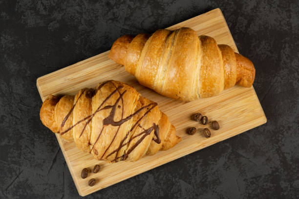 istock Two fresh croissants on a dark background. top view 1444190807